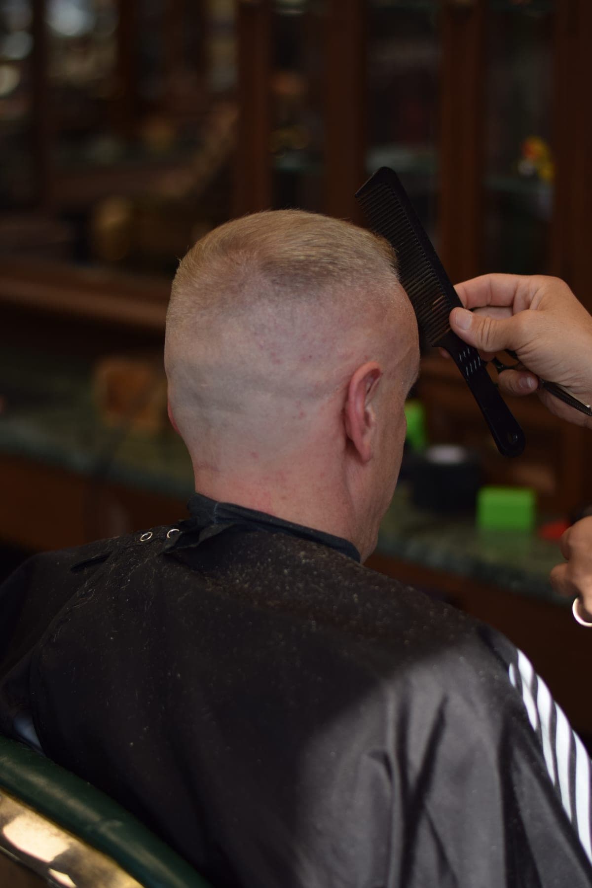 Barber checking a buzz cut with a comb at Porem Barbershop Amsterdam